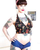 Long legged tattooed MILF Dollie Darko undressing to show spread ass