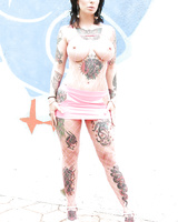 Tattooed Dollie Darko shows off her huge fake tits in fishnet bodysuit