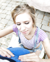 Blonde sitter Rachel James gives a fully clothed blowjob outdoors