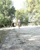 Pretty dark haired Yenna in shorts squats on the trail to take a long pee