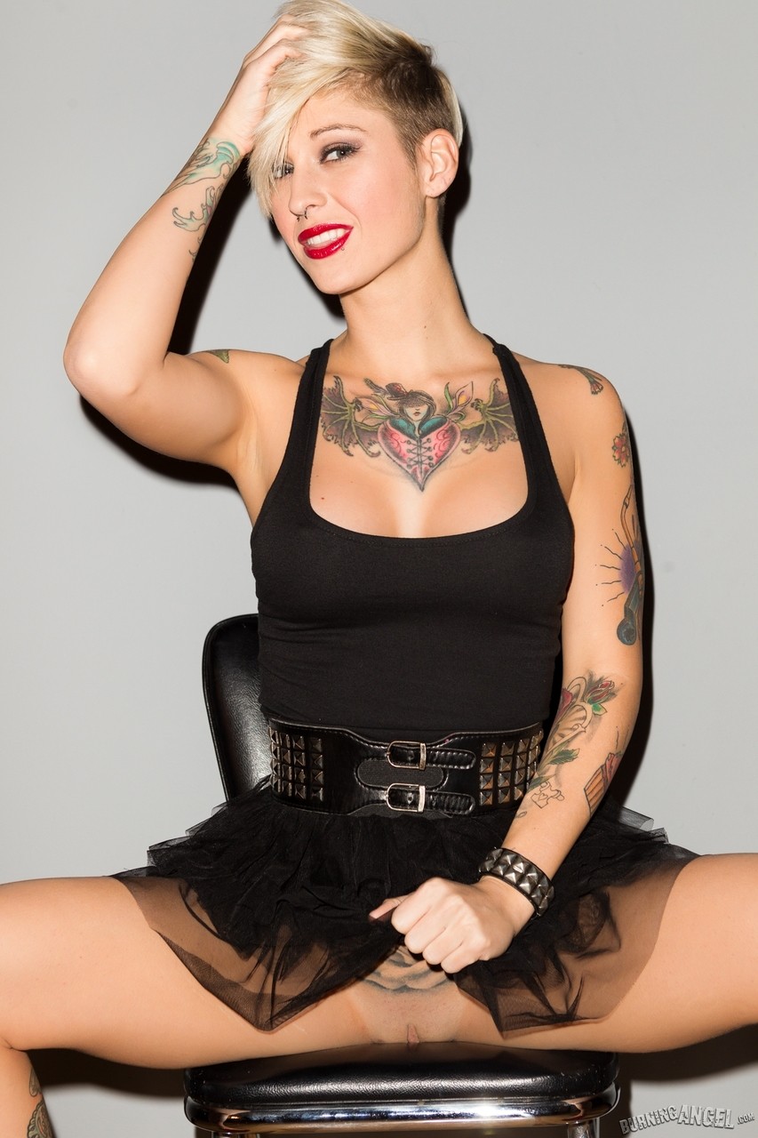 Tattooed female Kleio Valentien slips out of her black dress for nude poses