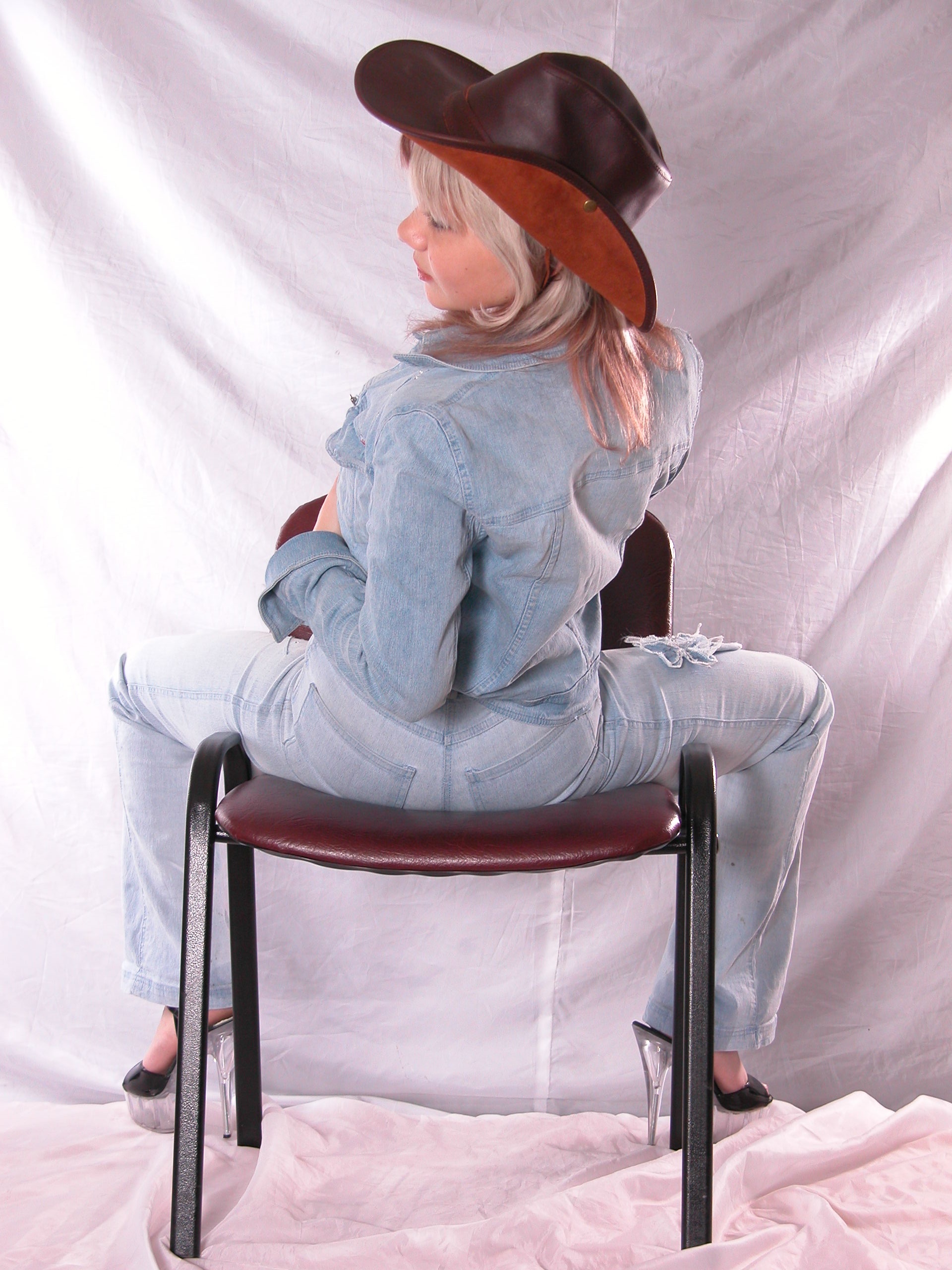 Girl in hat poses on the chair