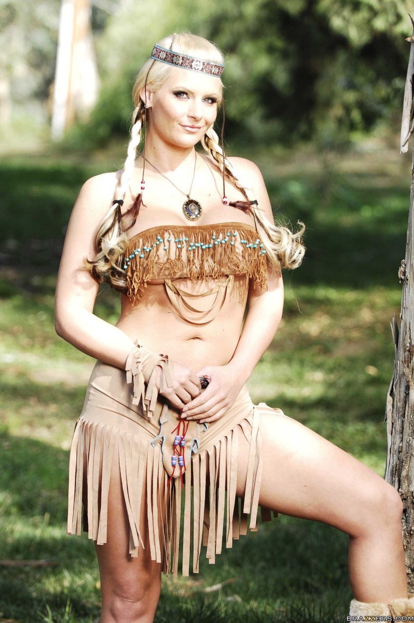 Blonde female Phoenix Marie works clear of her Indian attire in the woods