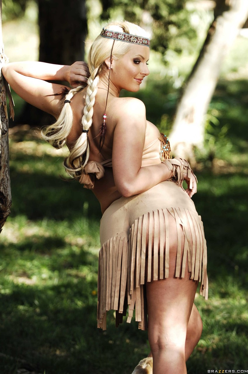 Blonde female Phoenix Marie works clear of her Indian attire in the woods