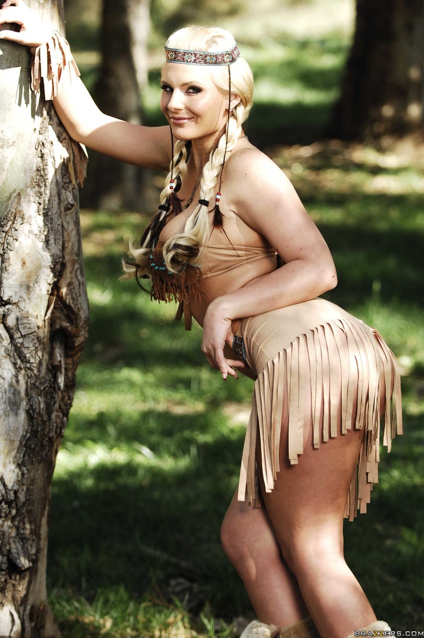 Blonde female Phoenix Marie works clear of her Indian attire in the woods